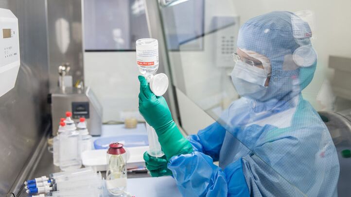 Ein Gesundheitsexperte in Schutzkleidung bereitet in einem Labor eine Infusion für die Onkologie vor.